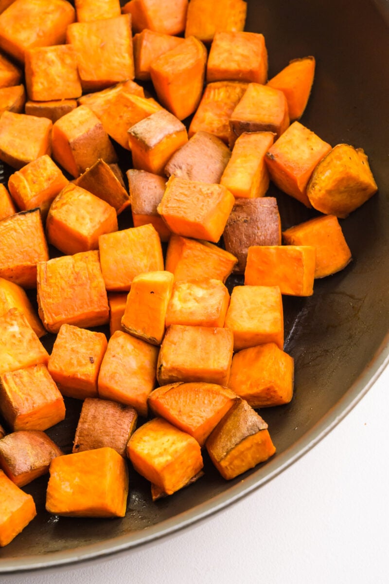 A pan holds cooked sweet potato cubes.