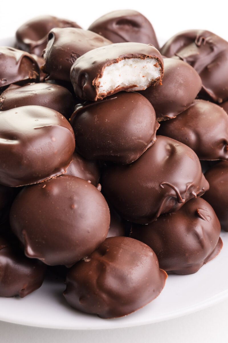 A plate of vegan junior mints has one on top with a bite taken out.