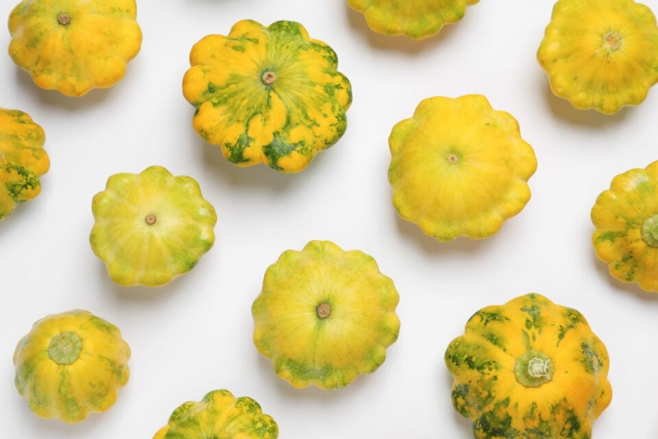 Looking down on a white table with several umbrella squash.