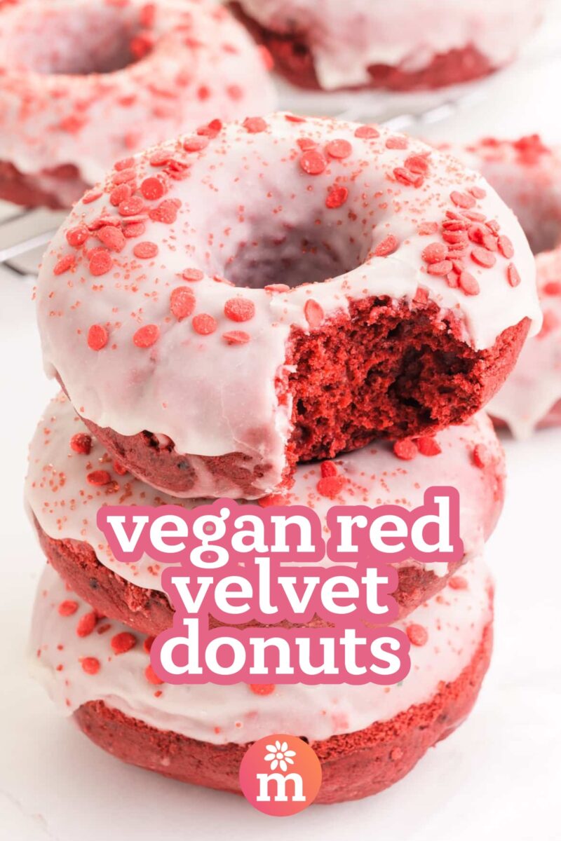 A stack of donuts shows the top one with a bite taken out. The text reads, vegan red velvet donuts.