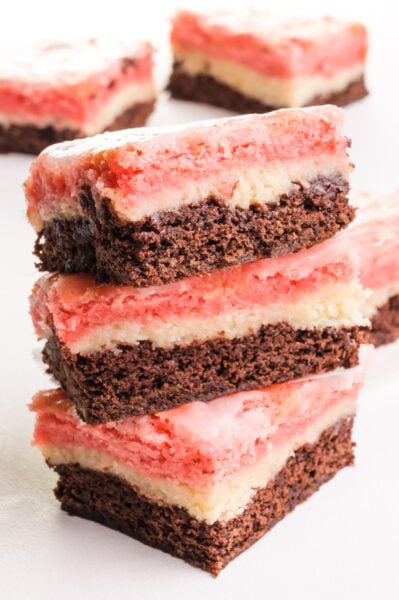 A stack of 3 Neapolitan Bar sits in front of more bars in the background.