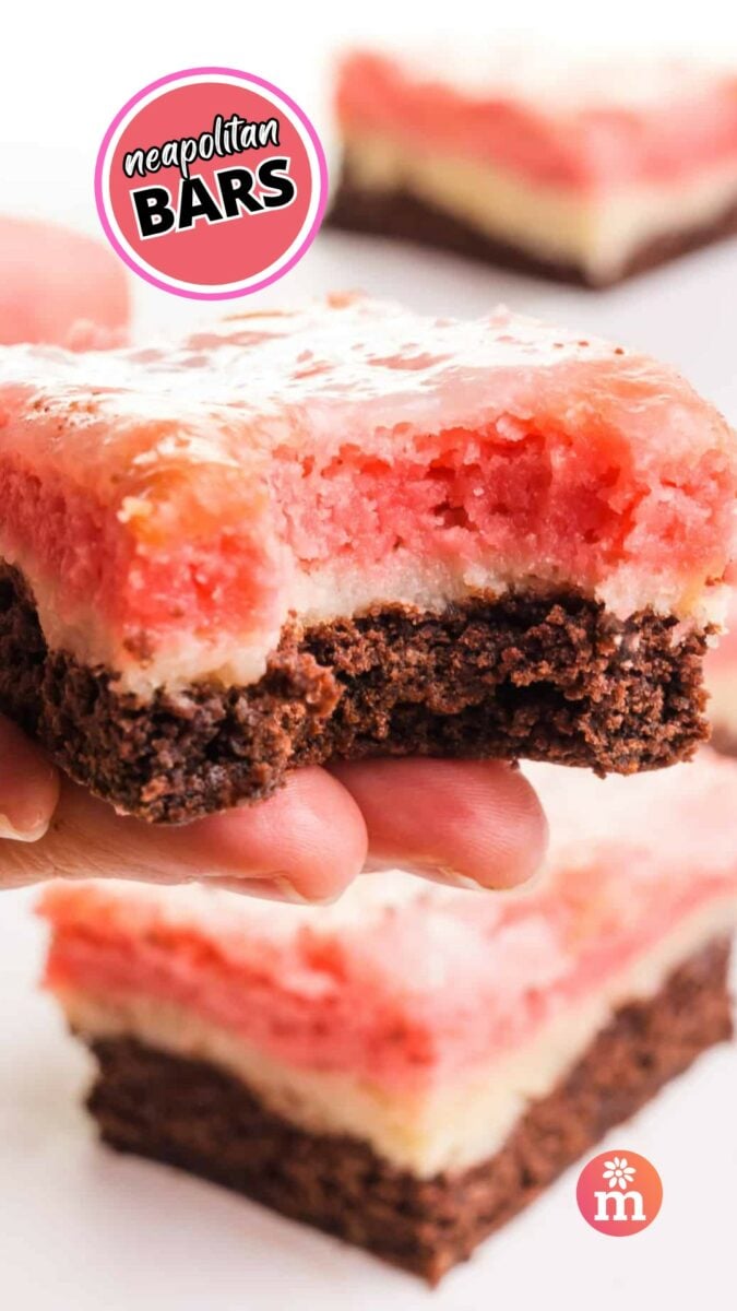 A hand holds a layered dessert bar with a bite taken out. The text on the image reads, Neapolitan Bars.