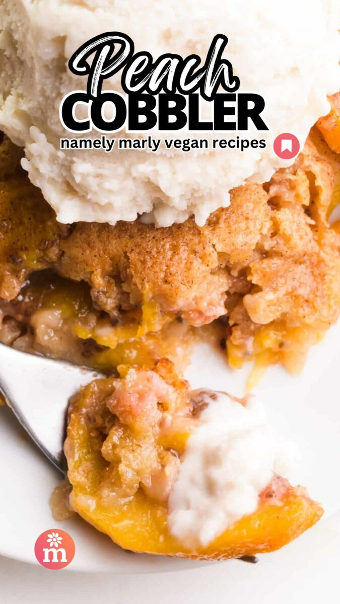 Looking down on a slice of peach cobbler with a bite sitting on a fork. The text reads, Peach Cobbler, Namely Marly Vegan Recipes.