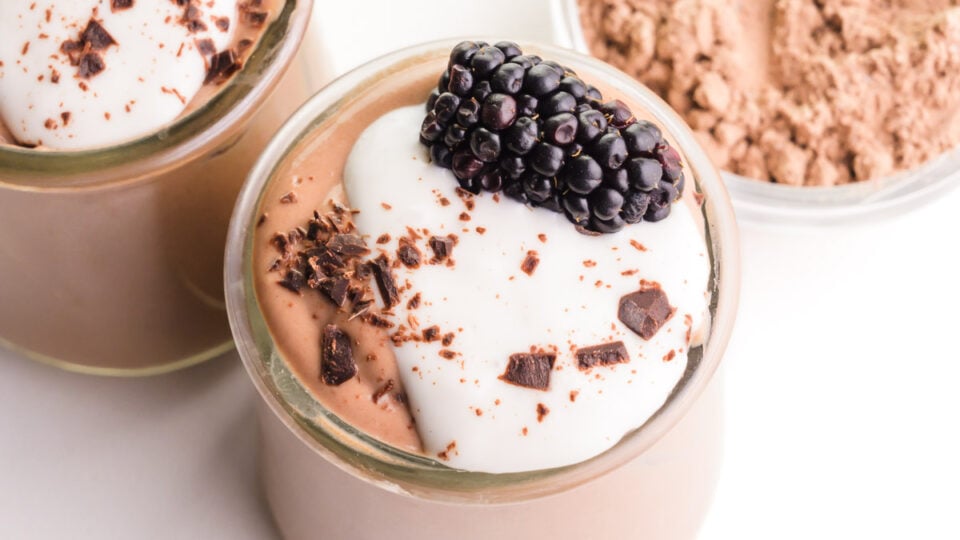 Looking down on a serving dish full of protein pudding, topped with yogurt and a berry.