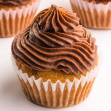 A cupcake has swirls of chocolate frosting on top.