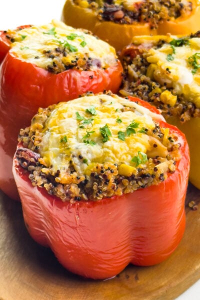 Bell peppers are stuffed with ingredients and topped with melted cheese.
