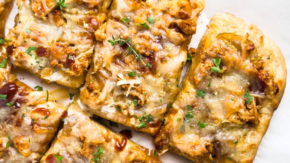 Slices of vegan sheet pan BBQ pizza on a white background.
