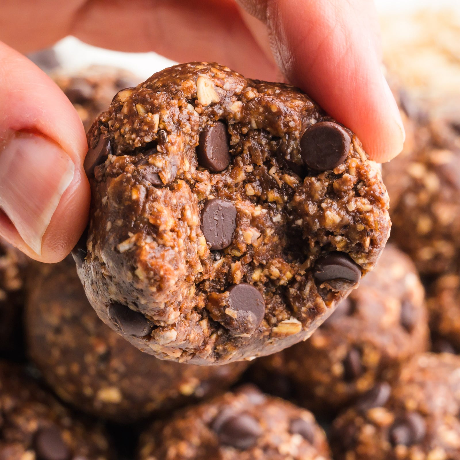A hand holds a Nutella energy ball with a bite taken out.