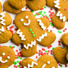 A gingerbread cookie is surrounded by other cookies and sprinkles.