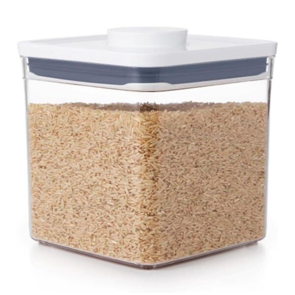 Clear container filled with brown rice, featuring a white lid and a rectangular shape.