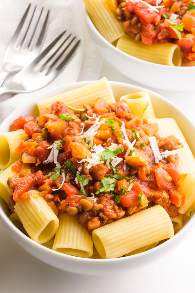 Two bowls of lentil bolognese have a couple of forks between them.