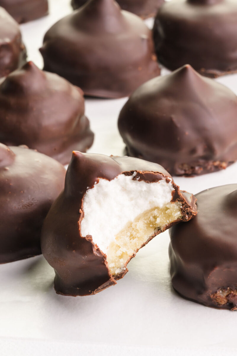 Several vegan mallomars one with a bite taken out tilted against another cookie.