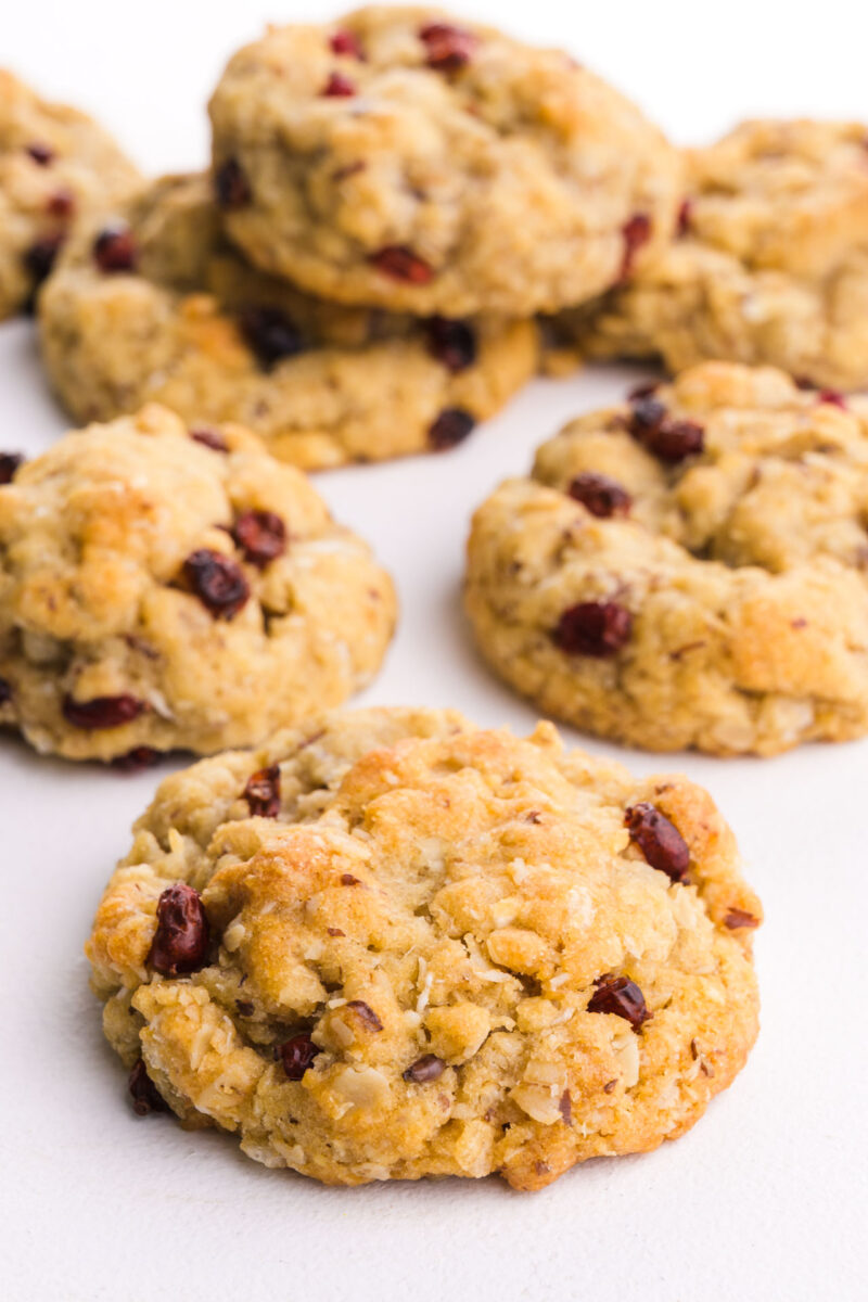 A bunch of oatmeal cookies on a white table top.