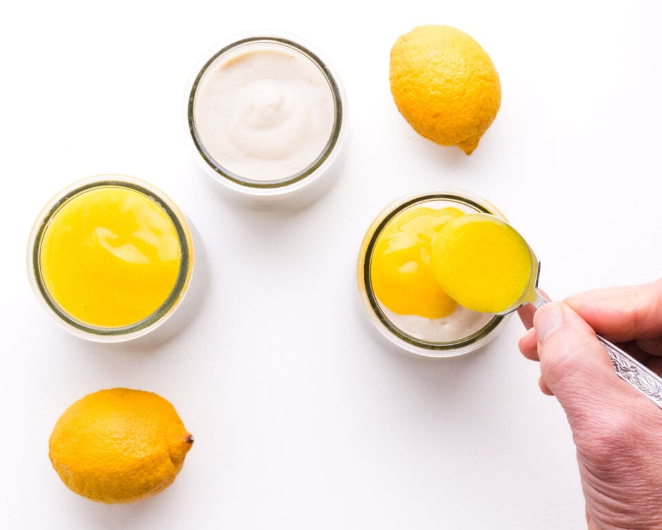 Lemon curd is being spooned on top of chia pudding.