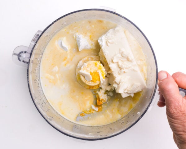 Silken tofu and other ingredients are in a food processor waiting to be blended.