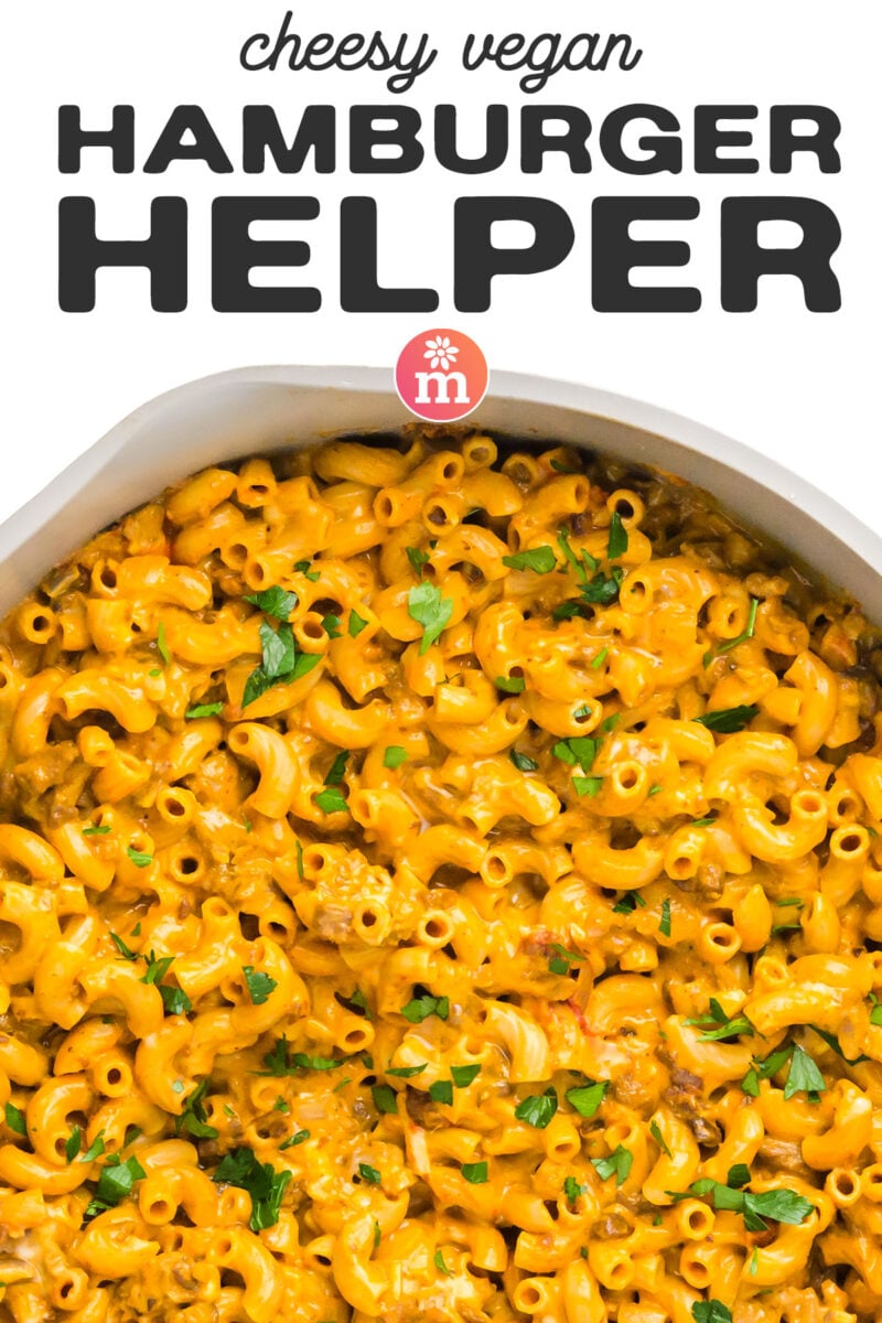 Cheesy vegan hamburger helper with pasta, garnished with fresh parsley in a white serving dish.