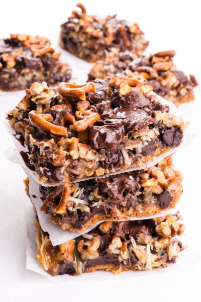 A stack of magic bars are on a white table with more of the treats behind it.