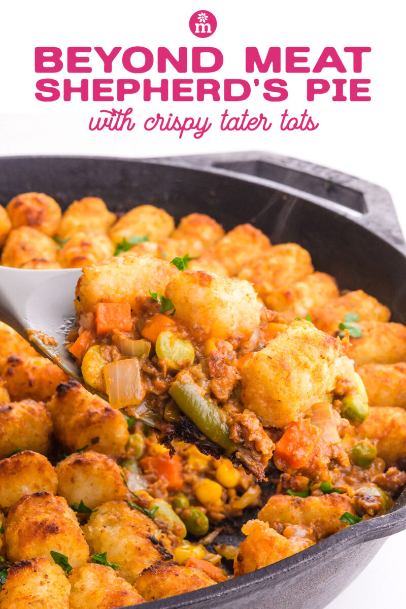 A spoonful of Beyond Meat shepherd's pie with crispy tater tots and mixed vegetables in a skillet.