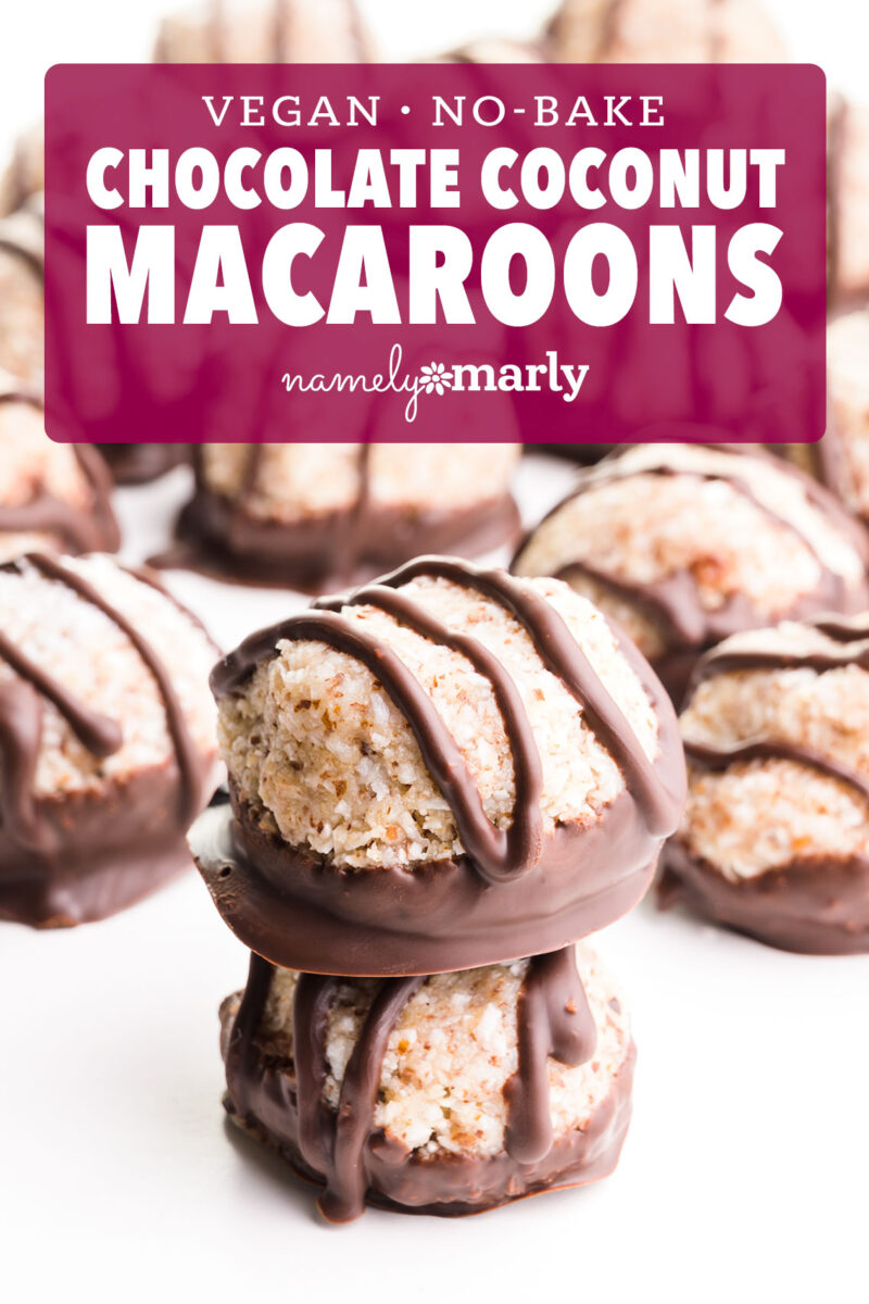 Vegan no-bake chocolate coconut macaroons drizzled with chocolate, stacked on a white surface.
