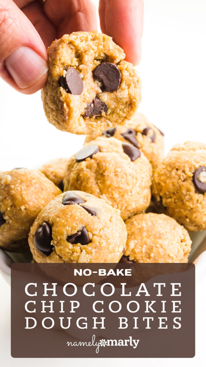 Hand holding a no-bake chocolate chip cookie dough bite above a bowl filled with more cookie dough bites.