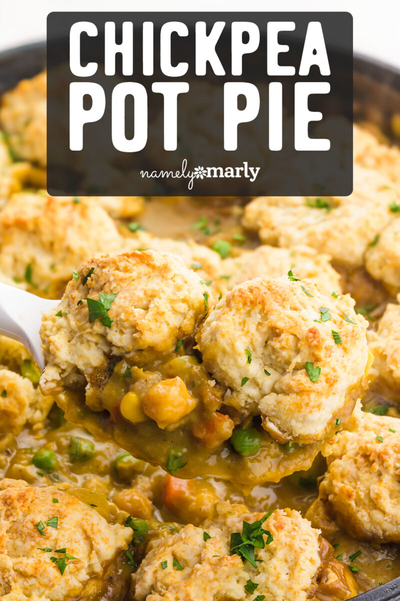 Chickpea pot pie with fluffy biscuit topping and mixed vegetables, garnished with fresh herbs in a skillet.