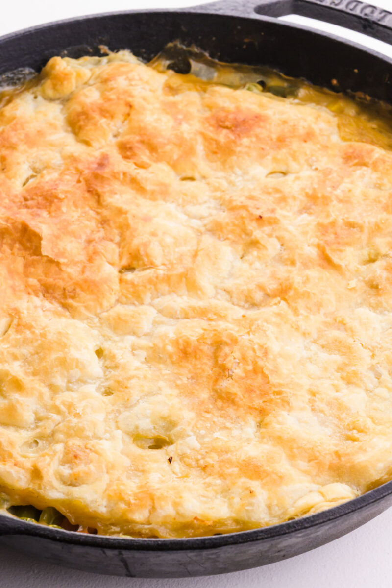 A golden crust in a skillet with vegan pot pie in it.