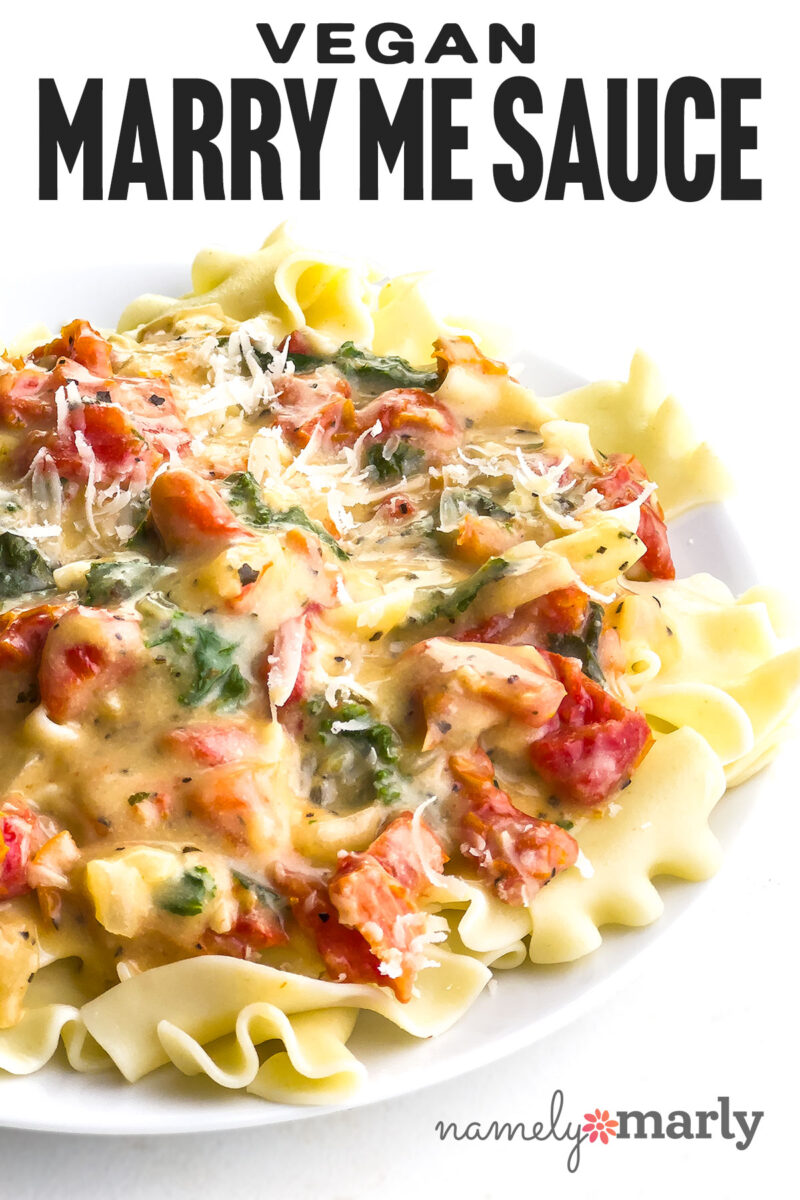 Vegan Marry Me Sauce served over pasta, featuring tomatoes, spinach, and a creamy sauce.