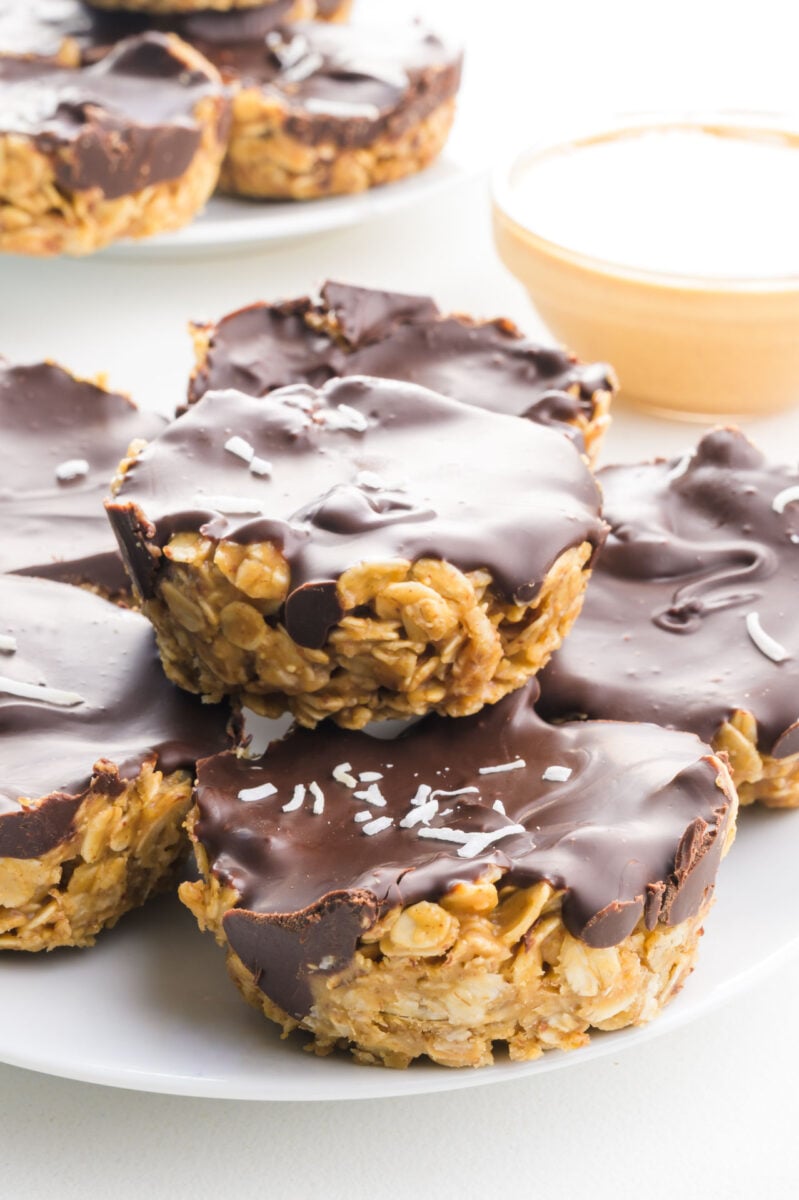 Several oatmeal cups topped with chocolate on a plate with more in the background.